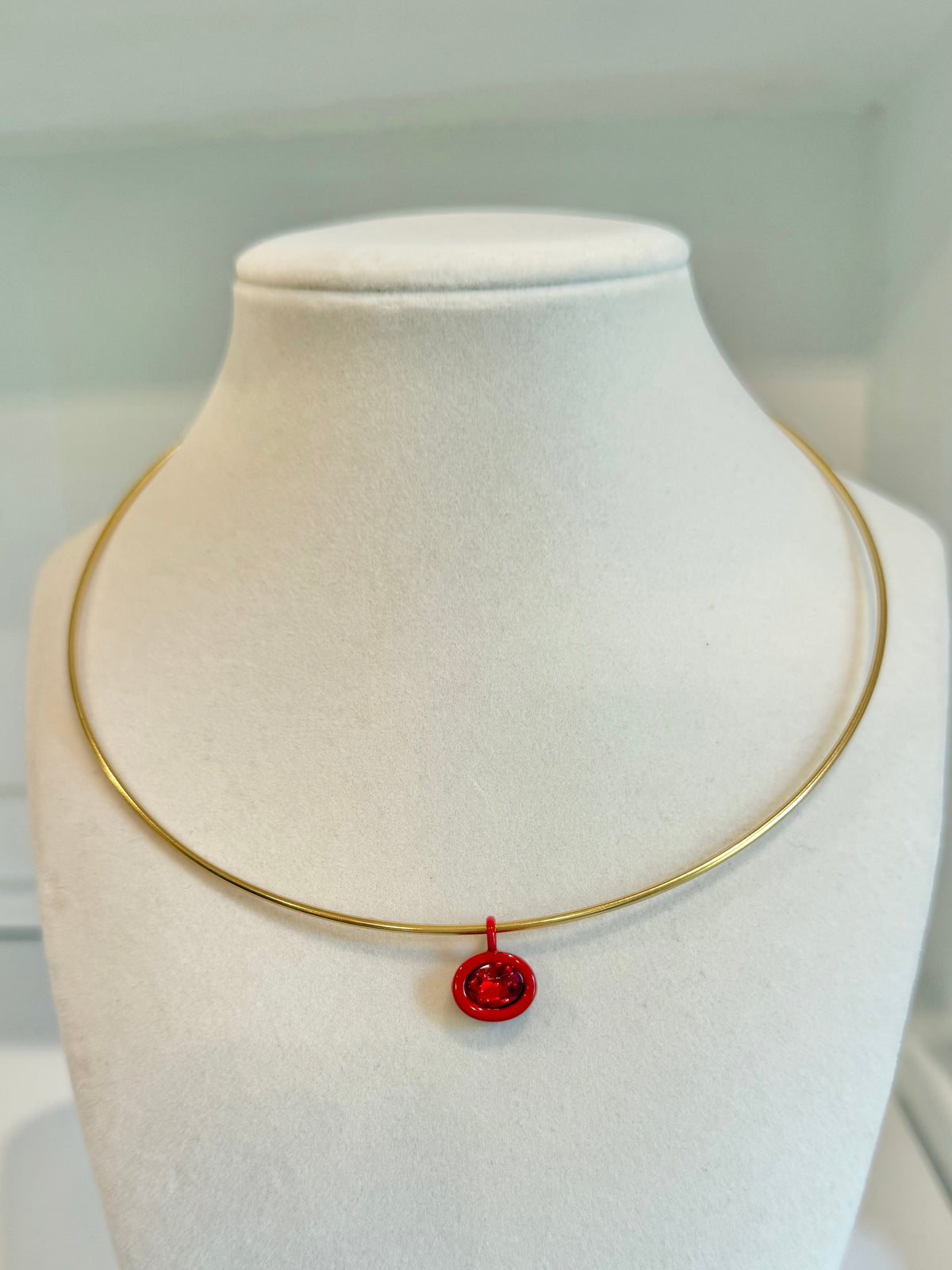 gold collar with red charm